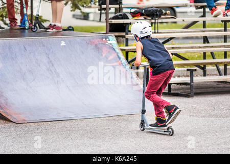 Saguenay, Kanada - Juni 3, 2017: Downtown City Sommer Park in Quebec mit junger Teenager boy Skaten, Tricks, Stunts auf Roller, Reiten auf Stockfoto