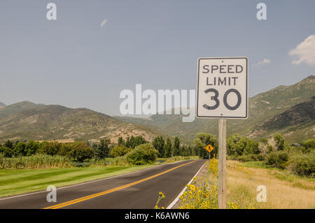 Was sich zu einer geraden Straße zu sein hat eine scharfe Kurve nach der Fußgängerampel Zeichen in dieser 30 mph Höchstgeschwindigkeit. Stockfoto