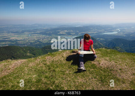 Junge Mädchen schaut auf die Karte in den Bergen Stockfoto