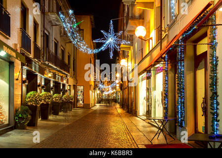 ALBA, Italien - 07 Dezember, 2011: Fußgängerzone und Geschäfte in der Altstadt von Alba beleuchtet und für Weihnachten dekoriert. Stockfoto