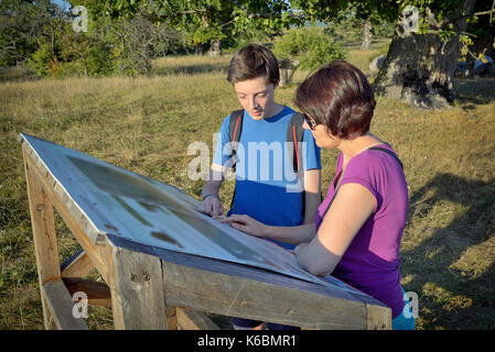 Familie mit Rucksäcken am Namensschild suchen Stockfoto