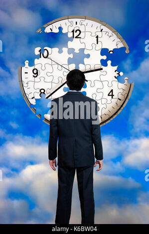 Geschäftsmann vor einem einer Uhr puzzle unvollendet, Zeit weg fliegen Konzept Stockfoto