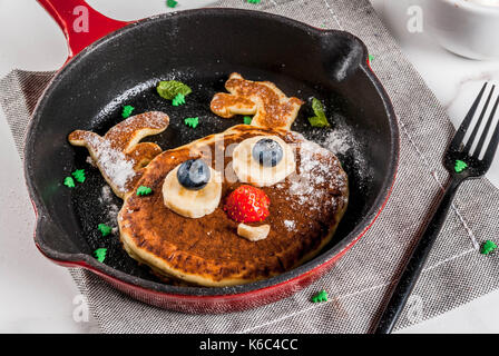 Lustig Essen für Weihnachten. Kinder Frühstück Pfannkuchen wie Rentier dekoriert, mit heißer Schokolade mit Marshmallows, weiße Tabelle kopieren Raum, Ansicht von oben Stockfoto