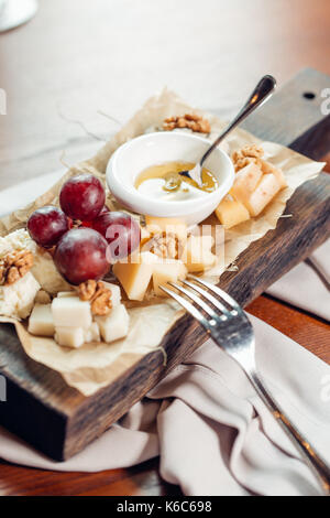 Vorspeise Bruschetta mit Birne, Honig, Haselnüsse und Hüttenkäse auf alten rustikalen Holzmöbeln Hintergrund, selektiver Fokus Stockfoto