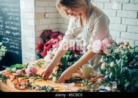 Kleine Unternehmen. Männliche florist unfocused im Blumengeschäft. Floral Design Studio, Dekorationen und Arrangements. Blumen Lieferung, die Ordnung Stockfoto