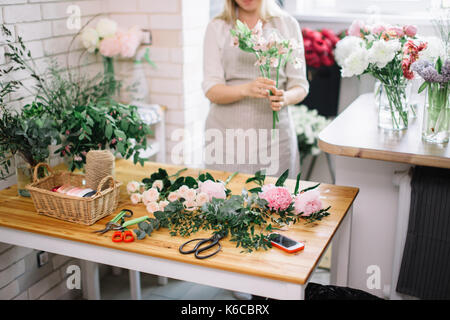 Kleine Unternehmen. Männliche florist unfocused im Blumengeschäft. Floral Design Studio, Dekorationen und Arrangements. Blumen Lieferung, die Ordnung Stockfoto