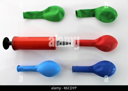 Ein Bild von einem weißen Luft-Pumpe Aufpumpen eines blauen Ballon auf weißem Hintergrund Stockfoto