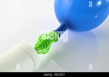 Ein Bild von einem weißen Luft-Pumpe Aufpumpen eines blauen Ballon auf weißem Hintergrund Stockfoto