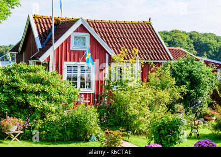 Karlskrona, Schweden - 28. August 2017: Reisen Dokumentarfilm von City Gardens. Red vintage Küsten Kabine mit Blumen und Sträucher im Garten. Stockfoto