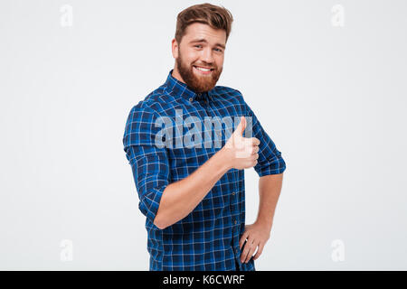 Positive casual bärtiger Mann über Weiß isoliert mit Daumen hoch Stockfoto
