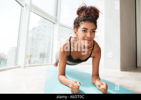 Konzentriert Sportlerin in Ganzkörperstütz beim Training zu Hause Stockfoto