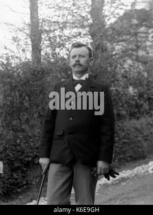 AJAXNETPHOTO. 1891-1910 (ca.). SAINT-LO REGION, Normandie, Frankreich. - Elegant gekleideten Mann mit Bow-tie, Jacke, SPAZIERSTOCK UND HANDSCHUHE IN EINER LANDSCHAFT AUF EINEM HÜGEL. Fotograf: unbekannt © DIGITAL IMAGE COPYRIGHT AJAX VINTAGE BILDARCHIV QUELLE: AJAX VINTAGE BILDARCHIV SAMMLUNG REF: AVL FRA 1890 B 29 X 1218 Stockfoto