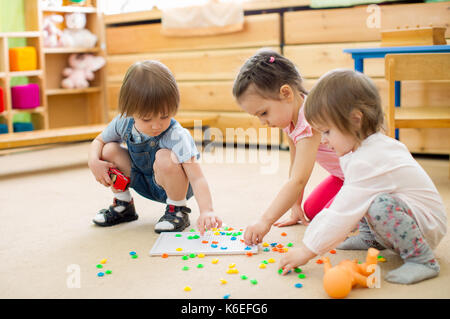 Kinder Gruppe spielen mosaik spiel im Kindergarten Stockfoto