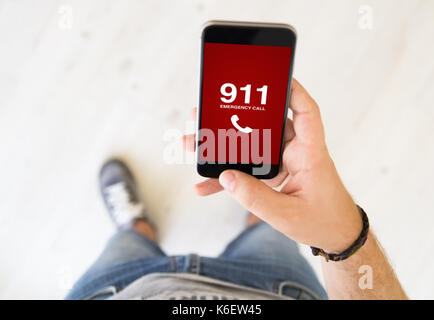 Nahaufnahme der männlichen Hand über Notruf 911 App smart phone Stockfoto