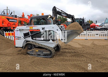 HYVINKAA, Finnland - 8 September, 2017: Fahrer bewegt den Eimer Sand in einer Arbeit Demo mit Bobcat T450 kompakte Kettenlader auf Maxpo 2017. Stockfoto