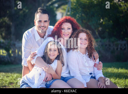 Glückliche Familie Mama, rpapa und zwei Töchter gegen Natur Hintergrund Stockfoto