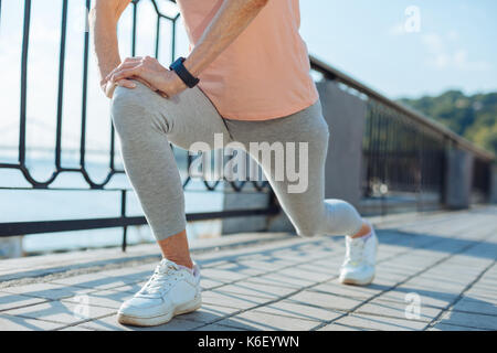 In der Nähe der älteren Frau stürzt vor Joggen Stockfoto