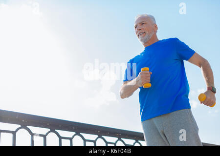 Athletischer Mann heraus arbeiten mit Kurzhanteln auf der Brücke Stockfoto