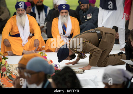 Ein Soldat zahlt seinen Respekt als der 120. Jahrestag der Schlacht von Saragarhi, der an 21 Sikh Soldaten, die, als Teil der 36th Sikh Regiment der Bengalen Infanterie der British Indian Army, gegen 10 000 Afghani stammesangehörigen am 12. September 1897 kämpften, wenn Sie die Saragarhi Außenposten in den Hügeln der North-West Frontier Province (jetzt in Pakistan), an der National Memorial Arboretum in Alrewas, Staffordshire verteidigt. Stockfoto