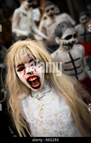 Eine salvadorianische Junge, mit Blut Gesicht Farbe, führt eine indigenen Mythologie Figur namens La Llorona in der La Calabiuza Parade am Tag der Dea Stockfoto