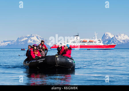 G Abenteuer Expedition Cruise Ship Passagiere erkunden auf See in einem Zodiac Beiboot in arktischen Gewässern an der norwegischen Küste. Helløya Troms Norwegen Stockfoto