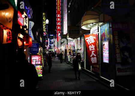 Tokio, Japan - Dezember 2016 - Unbekannter Mädchen gehen in den Straßen von Shinjuku bei Nacht Stockfoto