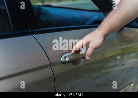 Der Mann öffnet die Autotür. Stockfoto