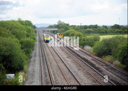 175007 (auf der Hauptleitung) und 150 242 (auf der Linie) in Richtung Westen nach Bestehen der Website von Marshfield Station. Stockfoto