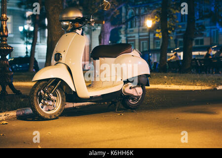 Weißer Motorroller in einer Nacht Stadt im Sommer Stockfoto