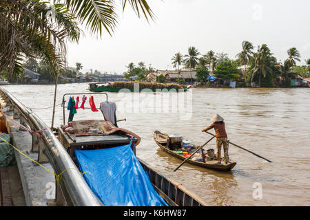 Eine Frau, die Paddles in Ihrem Boot auf dem Mekong River in Nga Bay, Vietnam Stockfoto