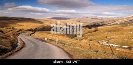 Eine einzelne Spur country lane klettert von dentdale oberhalb der Dent Kopf Viadukt über die Settle - carlisle Bahnlinie in die hügelige Moorlandschaft von Stockfoto