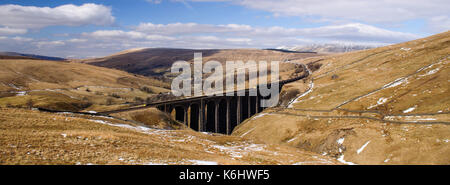 Eine Klasse 66 Diesellok schleppt einen Zug von Güterwagen über Arten gill Viadukt über moorlandschaften über dentdale in England yorkshire dales nationa Stockfoto