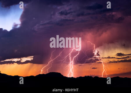 Bei einem Gewitter bei Sonnenuntergang in der Nähe von Wickenburg, Arizona, trifft eine Reihe von mächtigen Blitzeinschlägen Stockfoto