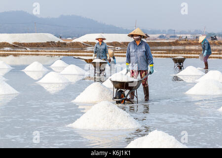 NHA TRANG, VIETNAM - 4/12/2016: Frauen Arbeiter am Hon Khoi Salz Felder in Nha Trang, Vietnam. Stockfoto