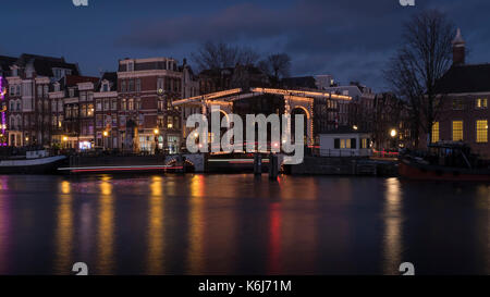 Abend geschossen von einem malerischen Brücke mit schönen Lichter am Fluss Amstel in Amsterdam, Niederlande. Stockfoto