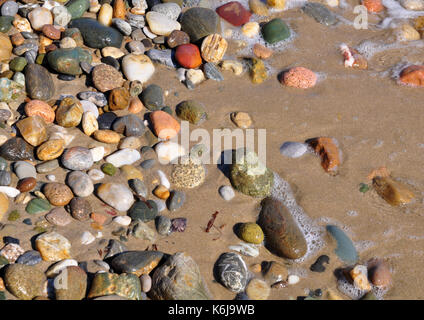 Bunte Steine, Meer und Sand Stockfoto