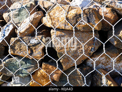 Zaun gefüllt Steine, Steine in metall draht Käfig Stockfoto