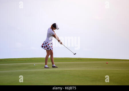 Junge Frau spielen Golf gegen klar weiß Himmel, Tanah Lot, Bali, Indonesien Stockfoto