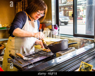 TOKYO, JAPAN - 5. AUGUST 2017: Nicht identifizierte Frau kochen Essen in einem Restaurant, in Tokio Stockfoto