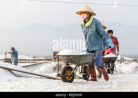 NHA TRANG, VIETNAM - 4/12/2016: Arbeiter in einer Linie an der Hon Khoi Salz Felder in Nha Trang, Vietnam. Stockfoto