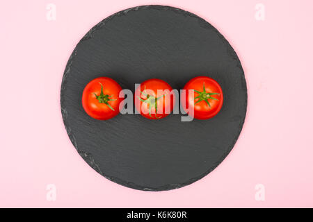 Kreative Gestaltung von roten Tomaten auf einem hellen Hintergrund. Studio Foto Stockfoto