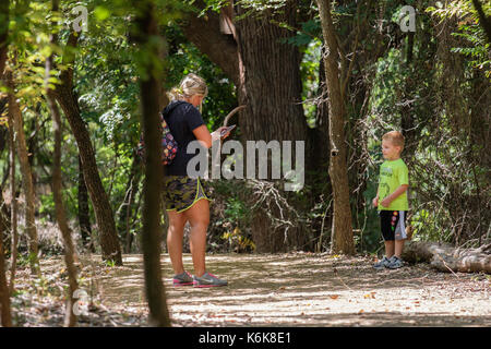 Ein im mittleren Alter kaukasische Frau nimmt ein kleiner Junge auf einer Natur Wanderung in Martin Park Nature Center, Oklahoma City, Oklahoma, USA. Stockfoto