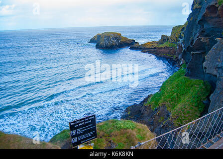 Ballintoy, Großbritannien - 2. Mai 2016: Carrick-a-Rede Rope Bridge, ein beliebtes Touristenziel in Nordirland. Touristen, die die Brücke passieren. Stockfoto