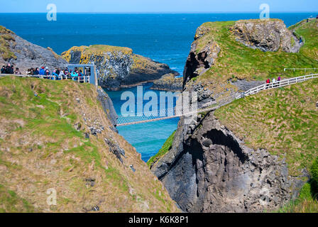 Ballintoy, Großbritannien - 2. Mai 2016: Carrick-a-Rede Rope Bridge, einem beliebten Reiseziel in Nordirland. Touristen und Geschäftsreisende, die auf der Brücke. Stockfoto