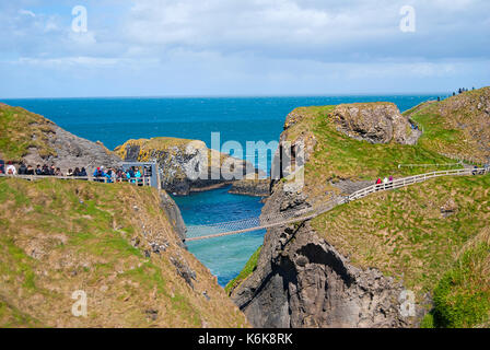 Ballintoy, Großbritannien - 2. Mai 2016: Carrick-a-Rede Rope Bridge, einem beliebten Reiseziel in Nordirland. Touristen und Geschäftsreisende, die auf der Brücke. Stockfoto