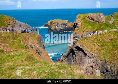 Ballintoy, Großbritannien - 2. Mai 2016: Carrick-a-Rede Rope Bridge, einem beliebten Reiseziel in Nordirland. Touristen und Geschäftsreisende, die auf der Brücke. Stockfoto