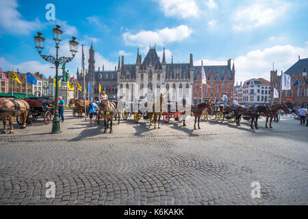 Pferdekutschen auf dem Grote Markt Platz in der mittelalterlichen Stadt Brügge am Morgen, Belgien. Stockfoto