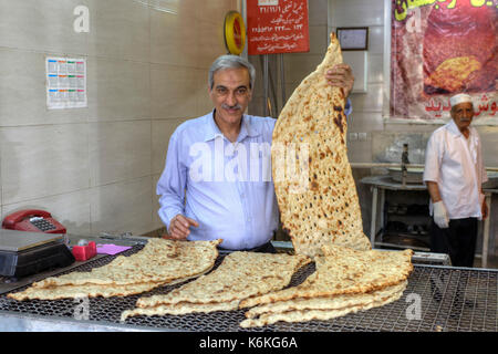 Provinz Fars, Shiraz, Iran - 18. April 2017: Shop in der Bäckerei, der Bäcker ist in seiner Hand die traditionelle iranische Fladenbrot lavash. Stockfoto