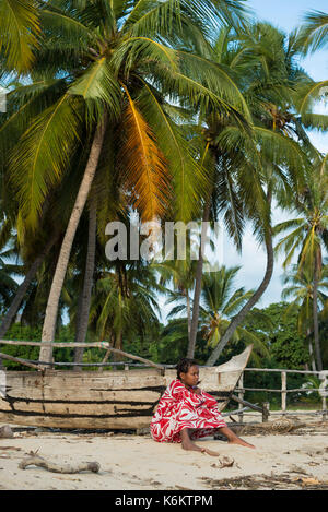 Frau sitzt auf der von Palmen gesäumten Strand, Nosy Be Madagaskar Stockfoto