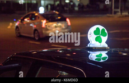 Taxi Service auf den Straßen von Kyoto am Abend. Green Shamrock scheint auf Taxi Auto Lampe. Stockfoto